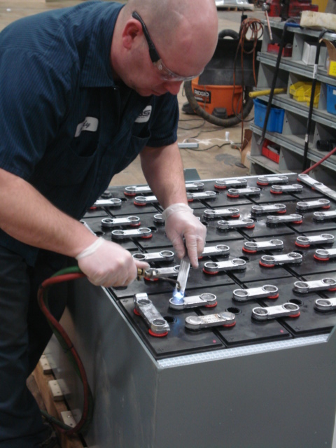Exponential Power worker repairing forklift battery