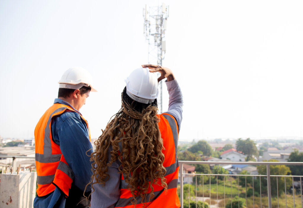 Team young engineer man and woman examining and checking station telecommunication at construction site, architect or inspector planning maintenance telecom tower, industry concept.